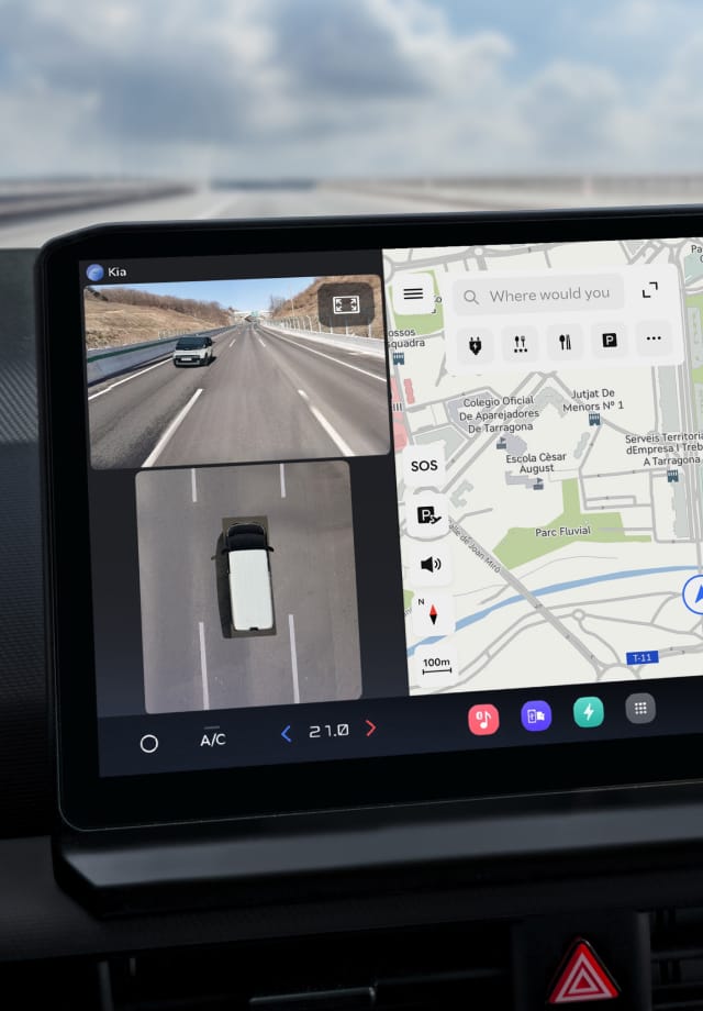 Nahaufnahme des Infotainment-Bildschirms mit Navigationskarte und Rückfahrkameraansicht.